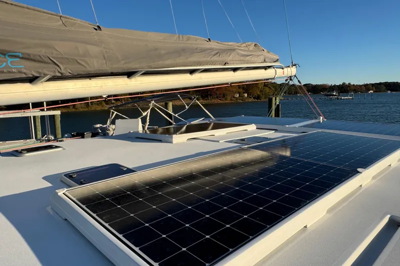 Hokule'a Yacht Photos Pics 2024 Balance 482 yacht with solar panels on deck, docked by a scenic waterfront.