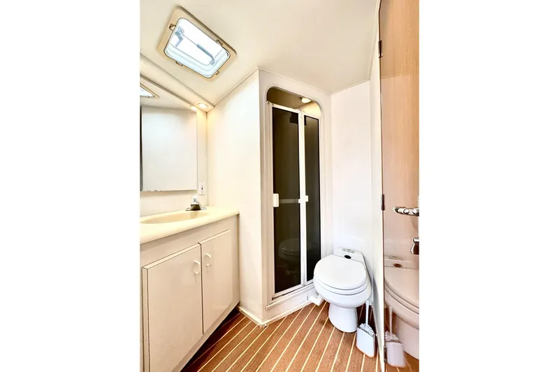Marlin Magic Yacht Photos Pics Bathroom interior of 1999 Viking 43 Convertible yacht, featuring shower, toilet, and vanity.
