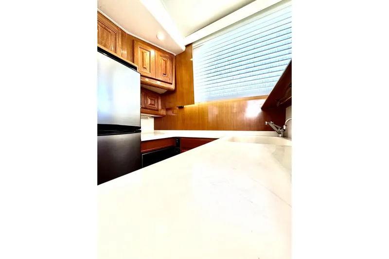 Marlin Magic Yacht Photos Pics Interior of 1999 Viking 43 Convertible yacht kitchen with wooden cabinets and stainless steel appliances.