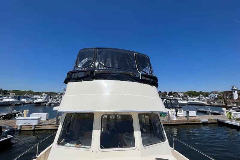  Yacht Photos Pics 2005 Mainship 400 Trawler docked at marina under clear blue sky.