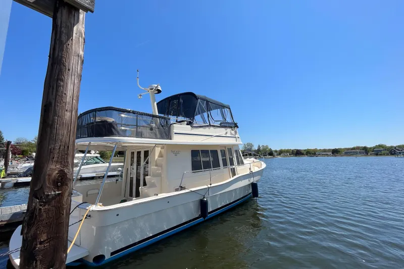  Yacht Photos Pics 2005 Mainship 400 Trawler docked on a sunny day by the water.