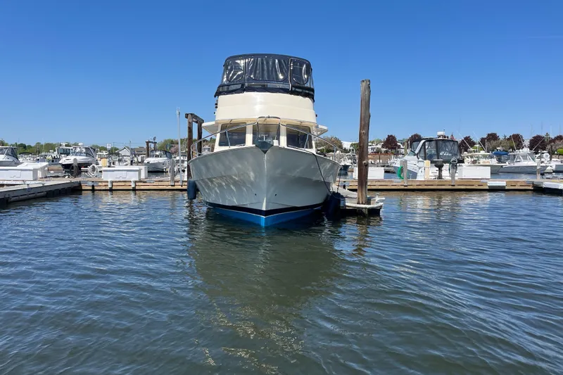  Yacht Photos Pics 2005 Mainship 400 Trawler docked in a marina under clear blue skies.