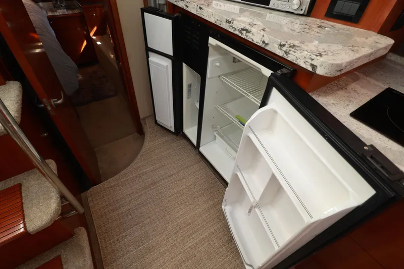 Nauti Buoy Yacht Photos Pics 2007 Cruisers 520 Express yacht interior with open refrigerator and modern kitchen amenities.