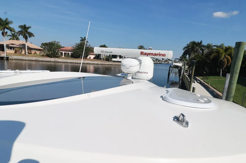 Nauti Buoy Yacht Photos Pics 2007 Cruisers 520 Express yacht with Raymarine radar, docked by palm trees and waterfront homes.