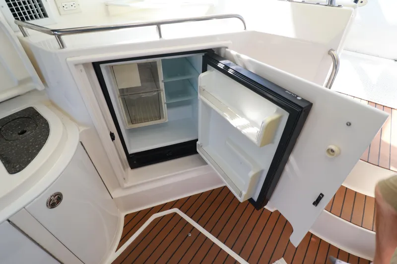 Nauti Buoy Yacht Photos Pics 2007 Cruisers 520 Express yacht interior with open mini fridge and wooden flooring.
