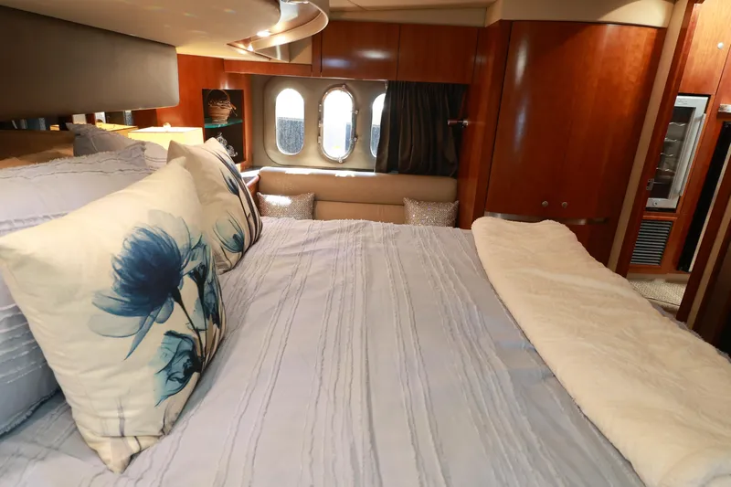 Nauti Buoy Yacht Photos Pics Luxurious bedroom interior of 2007 Cruisers 520 Express yacht with elegant bedding and wood paneling.