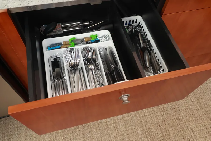 Nauti Buoy Yacht Photos Pics Open kitchen drawer with organized cutlery and utensils on a 2007 Cruisers 520 Express.