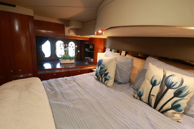 Nauti Buoy Yacht Photos Pics Luxurious 2007 Cruisers 520 Express yacht bedroom with elegant bedding and wooden cabinetry.