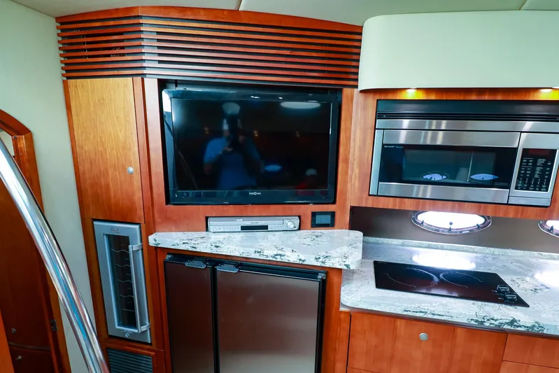 Nauti Buoy Yacht Photos Pics 2007 Cruisers 520 Express yacht interior with TV, microwave, and kitchenette.