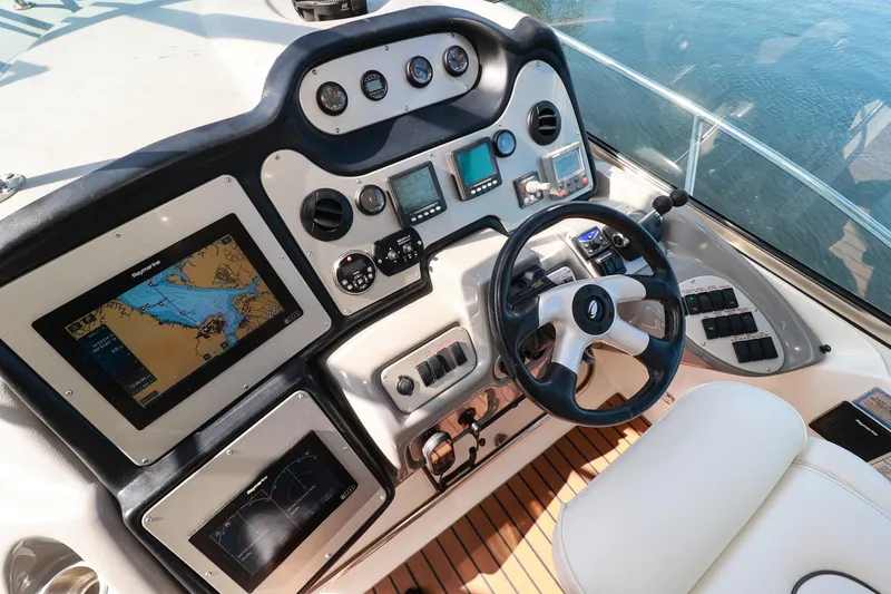 Nauti Buoy Yacht Photos Pics 2007 Cruisers 520 Express helm with navigation screens and controls on a sunny day.