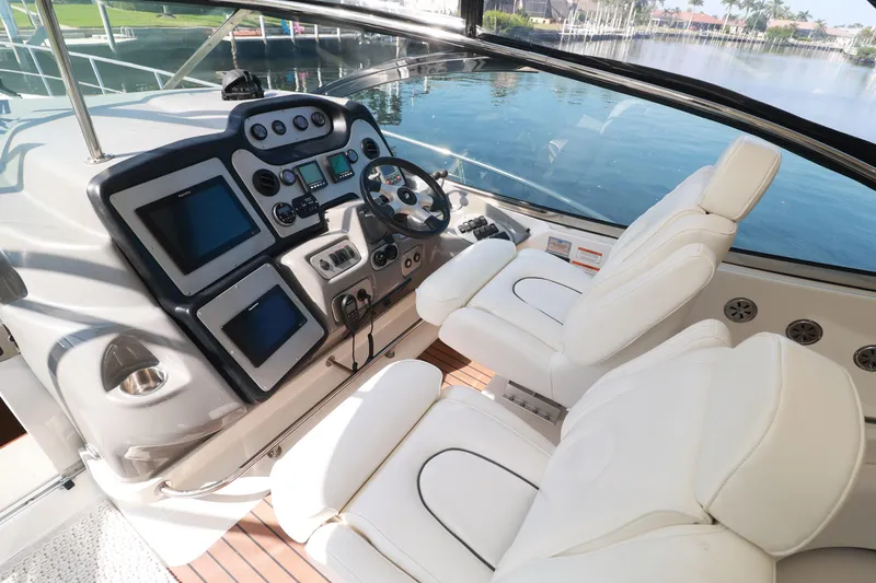 Nauti Buoy Yacht Photos Pics 2007 Cruisers 520 Express yacht helm with white seats and modern navigation controls.