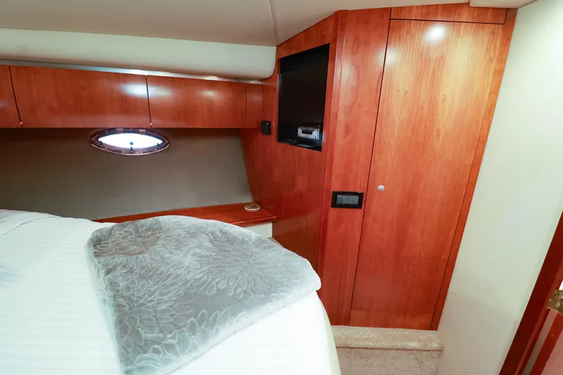 Nauti Buoy Yacht Photos Pics Luxurious 2007 Cruisers 520 Express cabin interior with wood paneling and cozy bedding.