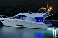 2008 Intermare 50 Fly Bridge yacht illuminated at night on calm water.