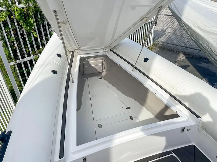  Yacht Photos Pics 2025 Ribco Venom 30 boat storage compartment, open lid, white interior, outdoor setting.