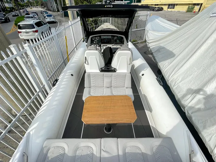  Yacht Photos Pics 2025 Ribco Venom 30 boat with sleek interior, white seating, and wooden table.