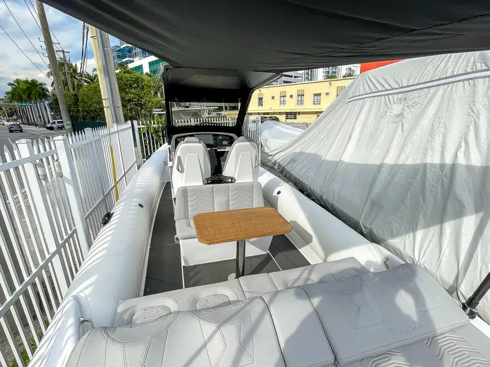  Yacht Photos Pics 2025 Ribco Venom 30 boat interior with seating and table under canopy.