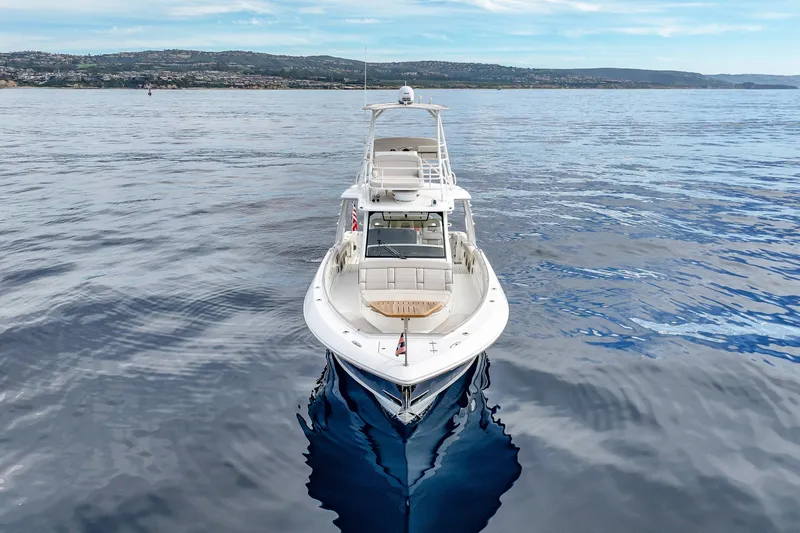 Fan Tail III Yacht Photos Pics 2018 Boston Whaler 420 Outrage on calm ocean waters with scenic coastline backdrop.