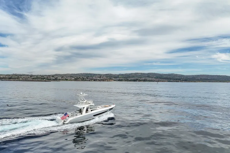 Fan Tail III Yacht Photos Pics 2018 Boston Whaler 420 Outrage cruising on calm waters under a cloudy sky.