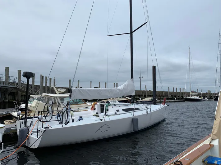 Ace Yacht Photos Pics 2019 J Boats J/121 sailboat docked at marina under cloudy sky.