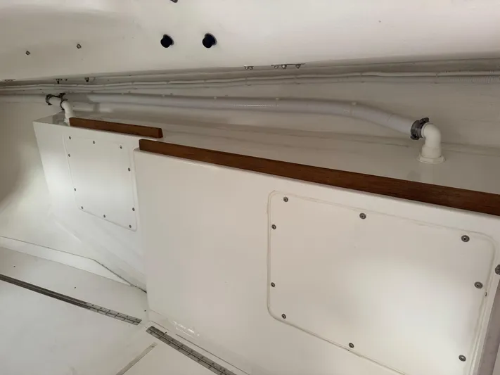 Ace Yacht Photos Pics Interior view of 2019 J Boats J/121 sailboat, showcasing storage compartments and piping.