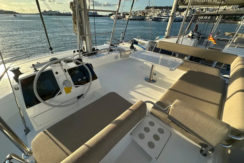 Platinum Yacht Photos Pics Modern 2023 Bali 4.6 yacht cockpit with steering wheel and seating, overlooking serene waters.