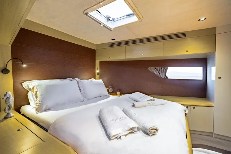  Yacht Photos Pics Luxurious bedroom interior of 2026 Phantom Spook Cabin Cruiser 62 yacht, featuring elegant bedding.
