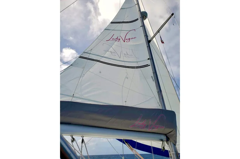 Lady Vague Yacht Photos Pics Sailing yacht Beneteau 50, 2001 model, with sails unfurled against a cloudy sky.