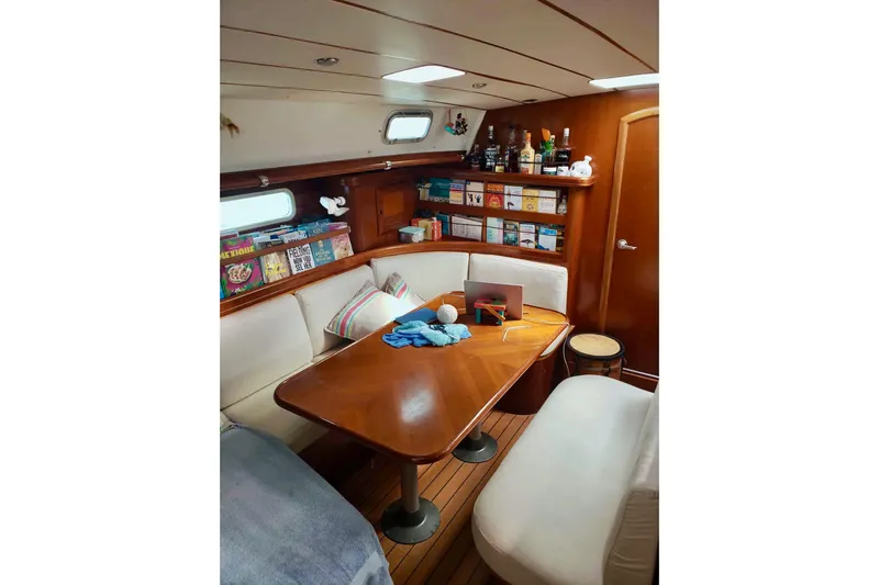 Lady Vague Yacht Photos Pics Cozy interior of 2001 Beneteau 50 yacht with books, drinks, and seating area.