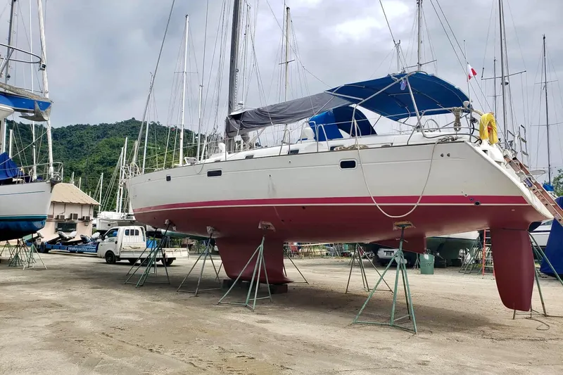 Lady Vague Yacht Photos Pics Sailboat Beneteau 50, 2001 model, on dry dock with scenic mountain backdrop.