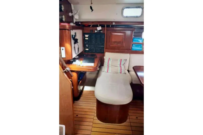 Lady Vague Yacht Photos Pics Interior of 2001 Beneteau 50 yacht with navigation station and cushioned seating.