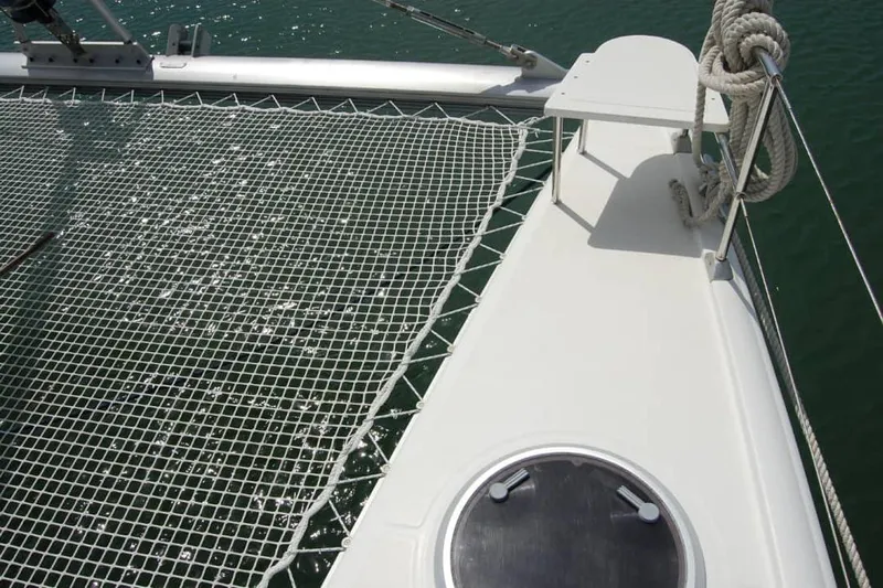  Yacht Photos Pics Fountaine Pajot Belize 43 catamaran deck with netting, 2006 model, on water.