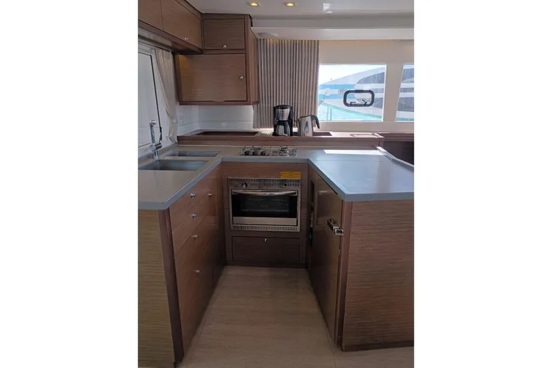  Yacht Photos Pics Modern kitchen interior of 2020 Lagoon 450 F yacht with wood cabinetry and appliances.