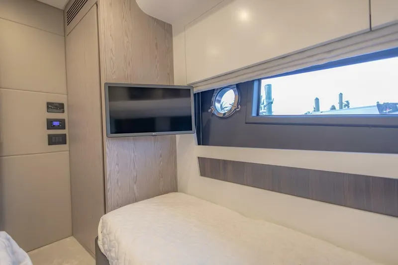 Asymmetry Yacht Photos Pics 2023 Azimut S6 Sport-Fly cabin interior with TV and porthole window.