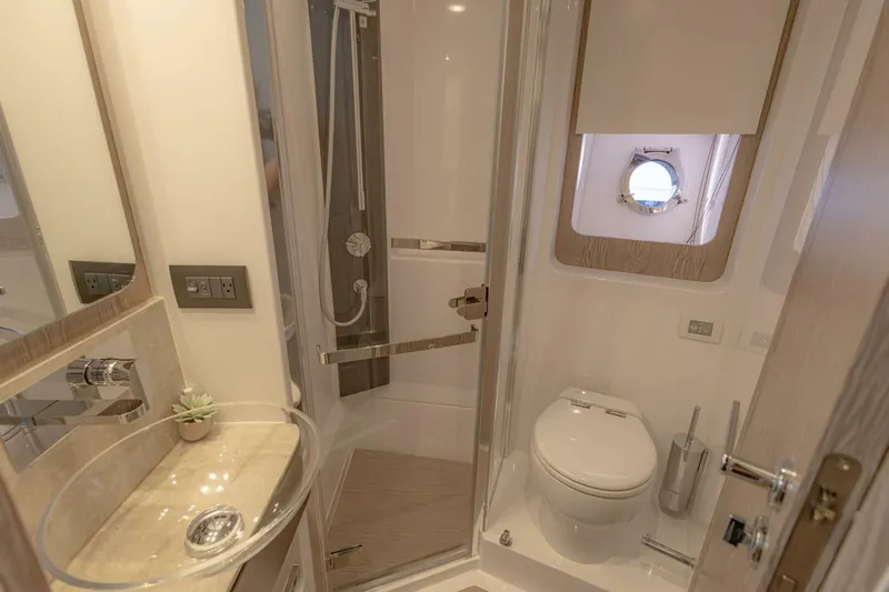 Asymmetry Yacht Photos Pics Luxurious bathroom in 2023 Azimut S6 Sport-Fly yacht with modern fixtures and porthole window.