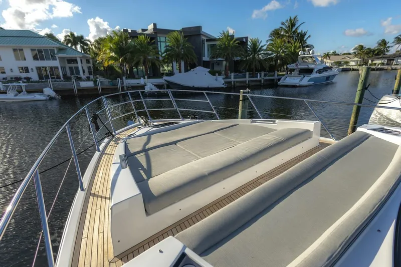 Asymmetry Yacht Photos Pics 2023 Azimut S6 Sport-Fly yacht with sunbathing area, docked in a scenic marina.