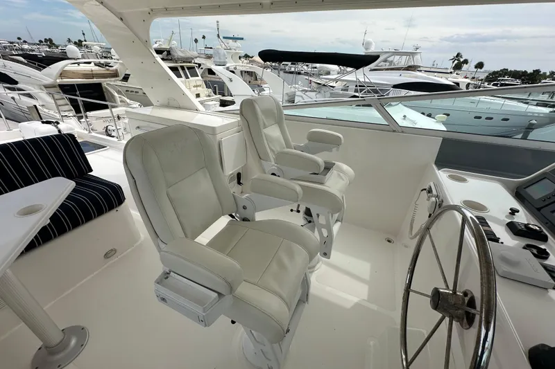 Odds Are Yacht Photos Pics 2003 Pacific Mariner 65 SE Motoryacht helm with white captain chairs and steering wheel.