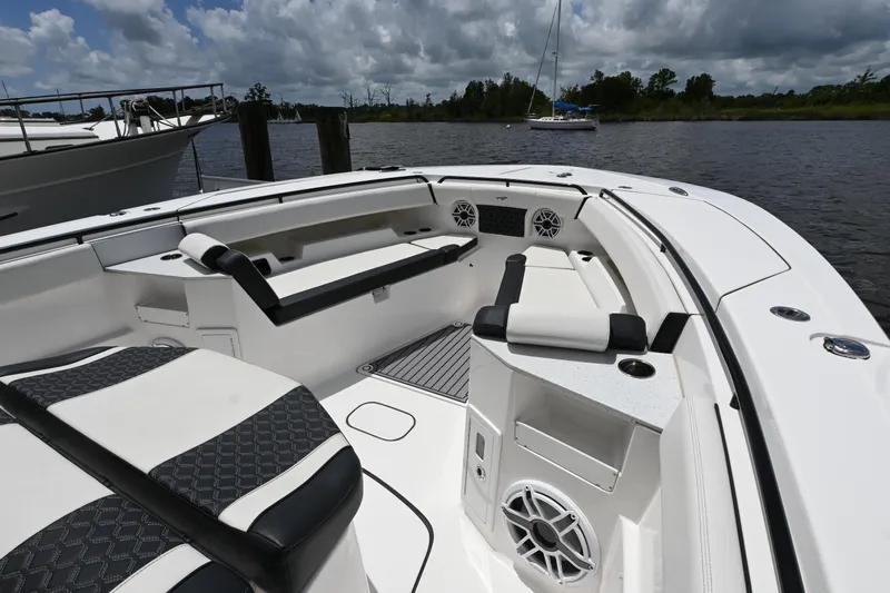  Yacht Photos Pics 2023 Tidewater 380 CC Adventure boat interior with seating and speakers on a calm waterway.