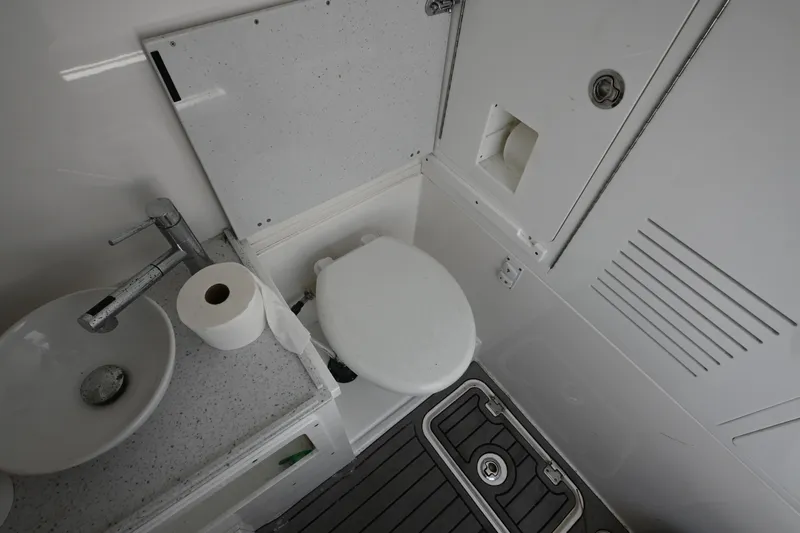  Yacht Photos Pics 2023 Tidewater 380 CC Adventure boat bathroom with sink, toilet, and storage.