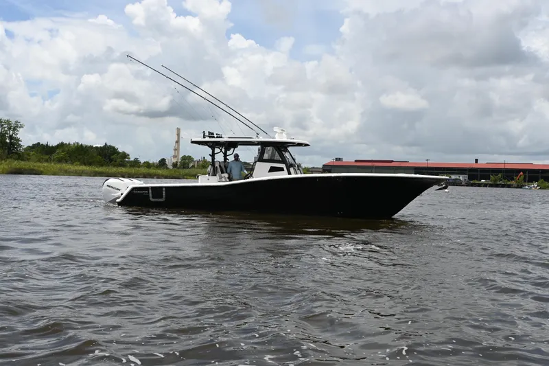  Yacht Photos Pics 2023 Tidewater 380 CC Adventure boat on a calm river under cloudy skies.
