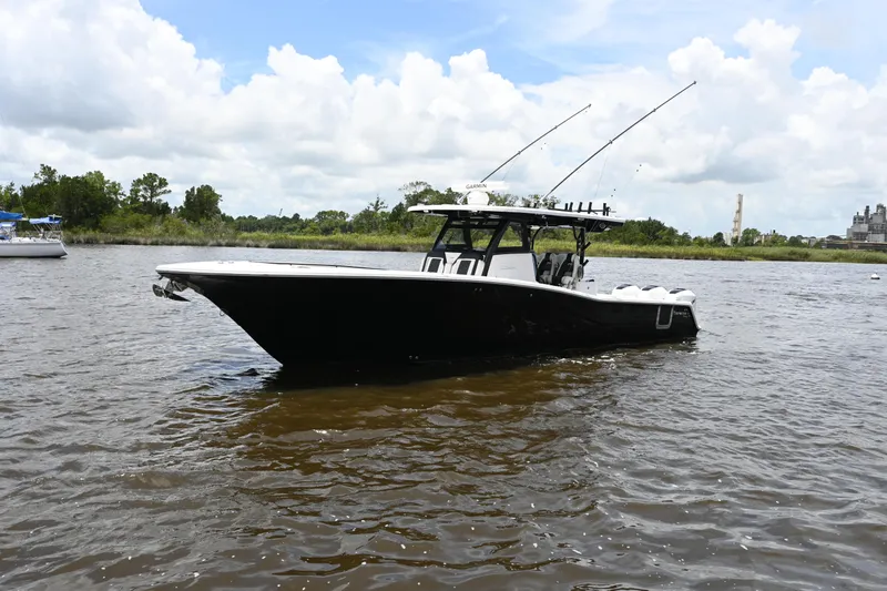  Yacht Photos Pics 2023 Tidewater 380 CC Adventure boat on a calm river under a cloudy sky.