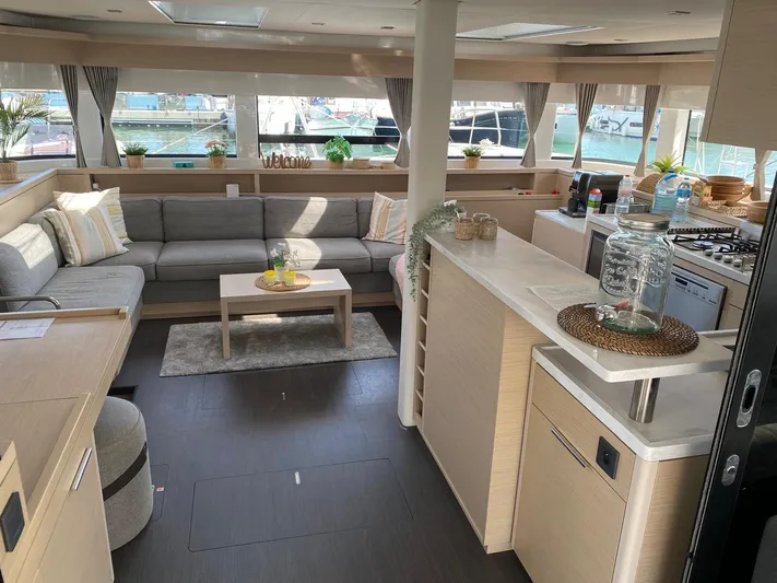 Slow Down Yacht Photos Pics Luxurious interior of 2023 Lagoon 55 yacht with modern kitchen and spacious seating area.