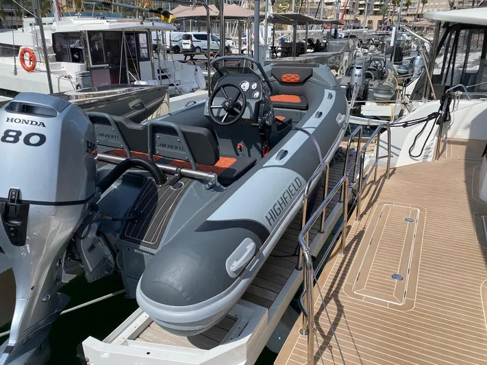 Slow Down Yacht Photos Pics Highfield inflatable boat with Honda 80 engine docked on Lagoon 55, 2023 model.