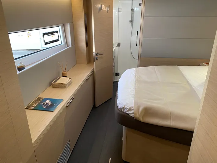 Slow Down Yacht Photos Pics Luxurious interior of 2023 Lagoon 55 yacht cabin with modern design and cozy bed.