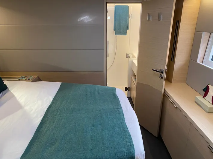 Slow Down Yacht Photos Pics Luxurious bedroom and bathroom interior of 2023 Lagoon 55 yacht, featuring modern design and amenities.