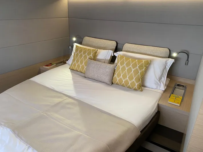 Slow Down Yacht Photos Pics Luxurious bedroom interior of 2023 Lagoon 55 yacht with elegant bedding and modern lighting.