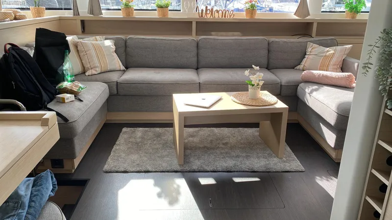 Slow Down Yacht Photos Pics Luxurious interior of 2023 Lagoon 55 yacht with cozy seating and decor.