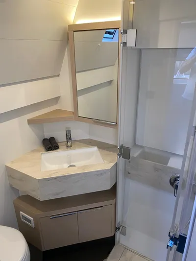 Slow Down Yacht Photos Pics Modern bathroom in 2023 Lagoon 55 yacht with sleek sink and mirror design.