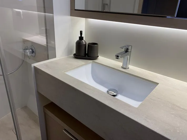 Slow Down Yacht Photos Pics Modern bathroom sink with sleek faucet and accessories on a Lagoon 55 yacht, 2023 model.