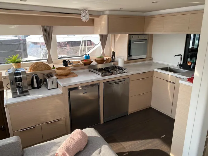 Slow Down Yacht Photos Pics Modern kitchen interior of 2023 Lagoon 55 yacht with appliances and sleek design.