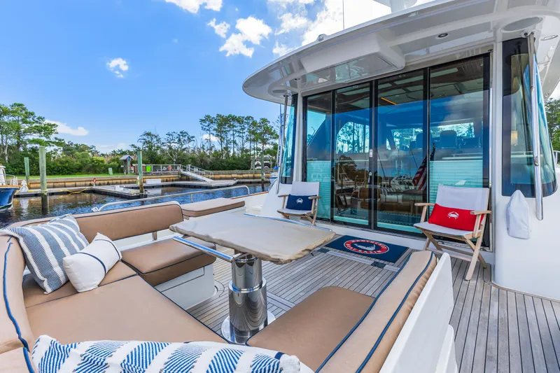 Sandcrab Yacht Photos Pics 2018 Sabre 66 Dirigo yacht with outdoor seating, docked by a scenic waterfront.